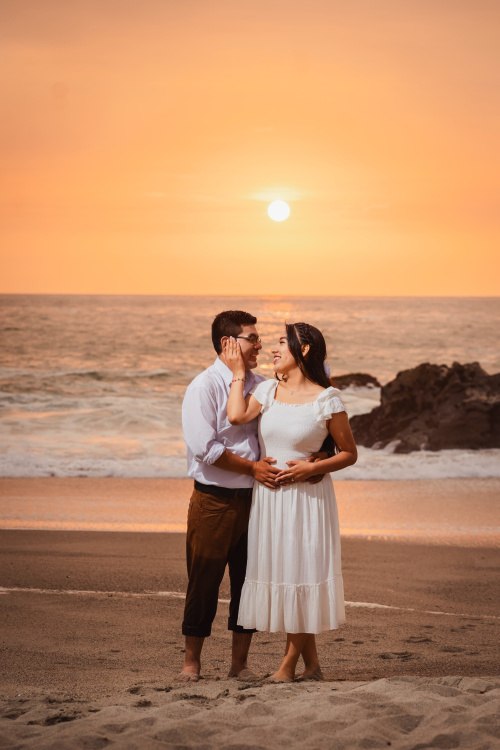 Pareja en la playa, ella coge el rostro de el tiernamente.